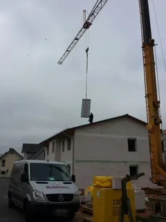 Der Kran hebt einen Kollektor aufs Dach