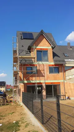 Das eingerüstete Haus mit den montierten Kollektoren